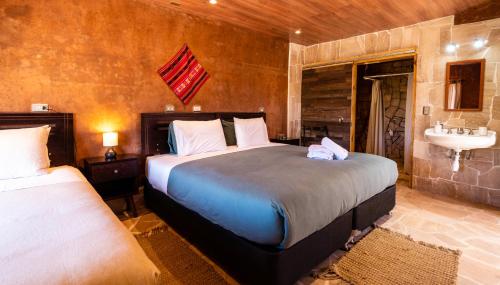 a bedroom with two beds and a sink in it at Foresta Atacama Lodge in San Pedro de Atacama