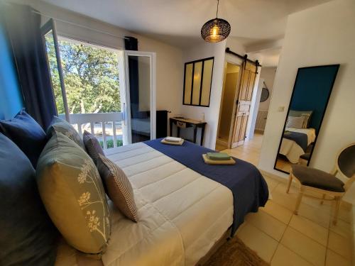 um quarto com uma cama grande e uma varanda em LA FONTAINE AU LOUP em Saint-Maurice-sur-Eygues