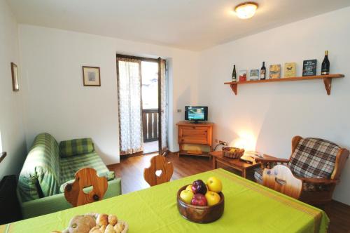 a living room with a table with a bowl of fruit on it at Casa Molini in Malè