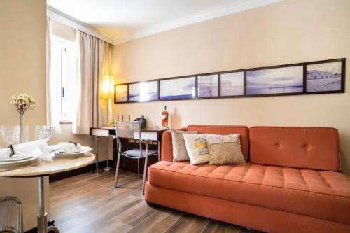 a living room with a couch and a table at FLAT PRIME COM PISCINA Na REGIÃO DA PAULISTA - JARDINS in Sao Paulo