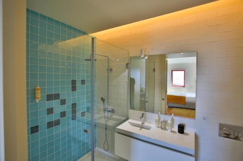 y baño con ducha acristalada y lavamanos. en 4CITY FLAT CAMARÃO, en Oporto
