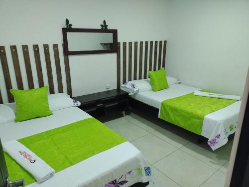 Zimmer mit 2 Betten und grüner Bettwäsche in der Unterkunft Hotel plaza centro in Florencia