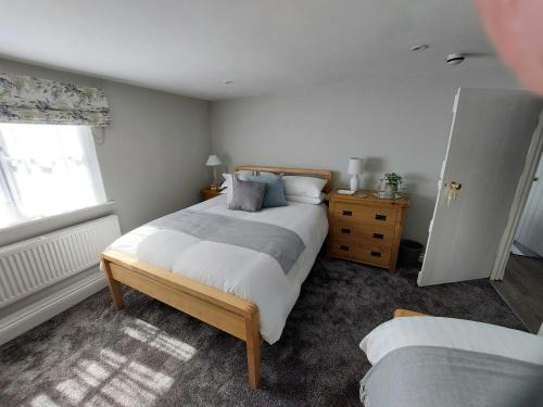 um quarto com uma cama grande e uma janela em The White Hart Apartment Church View em Alton