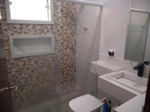 a bathroom with a toilet and a sink and a shower at Casa Pra temporada in Aparecida