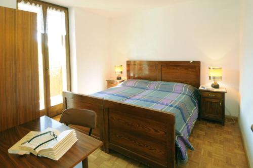 a bedroom with a bed with a desk and a table with books at Casa Anselmi in Croviana