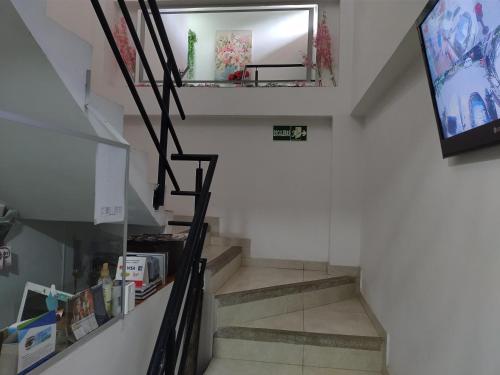 a staircase in a house with a tv and a mirror at Hotel plaza centro in Florencia