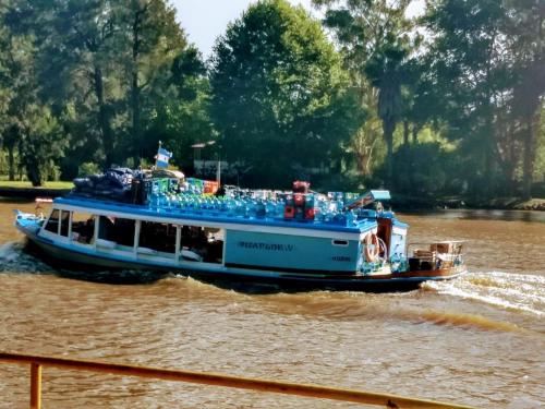 a ferry boat traveling down a river at Delta Tigre in Tigre