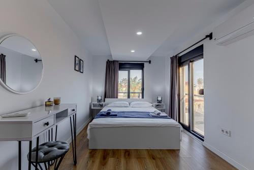 Schlafzimmer mit einem Bett, einem Schreibtisch und einem Spiegel in der Unterkunft the north villa in Belek