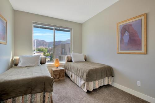 a small bedroom with two beds and a window at Entrada at Moab 598 and 602 in Moab