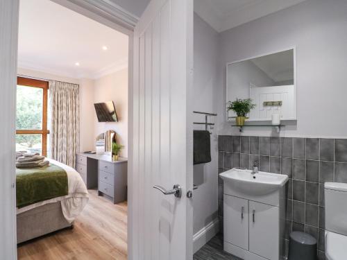 a bathroom with a sink and a bed and a mirror at Avenue Croft in Nottingham