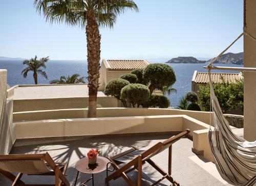 a patio with a hammock and a view of the ocean at Seaside A Lifestyle Resort - Adults Only in Agia Pelagia