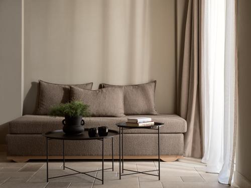 a living room with a couch and two tables at Seaside A Lifestyle Resort - Adults Only in Agia Pelagia