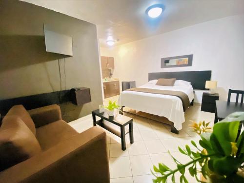 une chambre d'hôtel avec un lit et un canapé dans l'établissement OB Studios, à Saint-Domingue