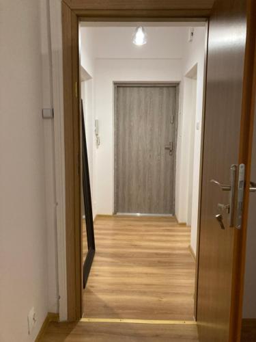 - un couloir avec une porte menant à une chambre dans l'établissement Apartament Chrobrego 30/3, à Zielona Góra