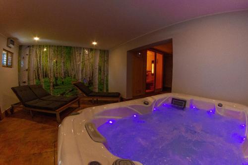 a jacuzzi tub with purple lights in a room at Andy's Holiday Home with HotTub & Sauna 
