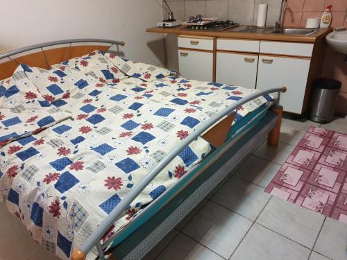 Una cama con un edredón en la cocina en Apartmant en Donji Miholjac