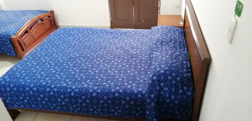 a bedroom with a bed with a blue comforter at HOTEL LA REPUBLICA MANIZALES in Manizales