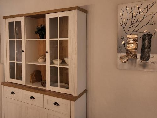 a white cabinet with glass doors in a room at Schöne Ferienwohnung in Traumlage FeWo SoloHike in Seelisberg