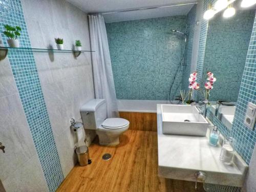 y baño con aseo, lavabo y espejo. en Panorama Córdoba Center, baño compartido en Córdoba
