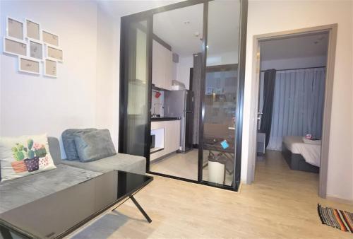 a living room with a couch and a table at LLX Apartments at The Base condo in Pattaya Central