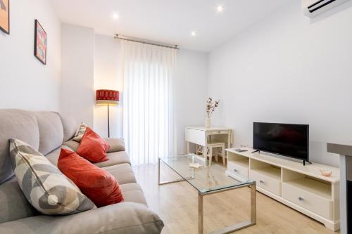 a living room with a couch and a tv at Charming 2 Bedroom Apartment Triana Bridge By Oui Seville in Seville