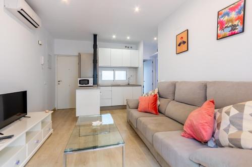 a living room with a couch and a television at Charming 2 Bedroom Apartment Triana Bridge By Oui Seville in Seville