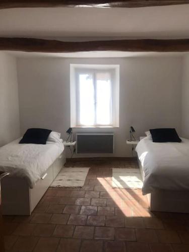 une chambre avec deux lits et une fenêtre dans l'établissement Charming village house for 6 people, à Baudinard