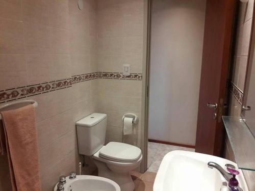 a bathroom with a toilet and a sink at IEMANJA Depto Villa Gesell in Villa Gesell