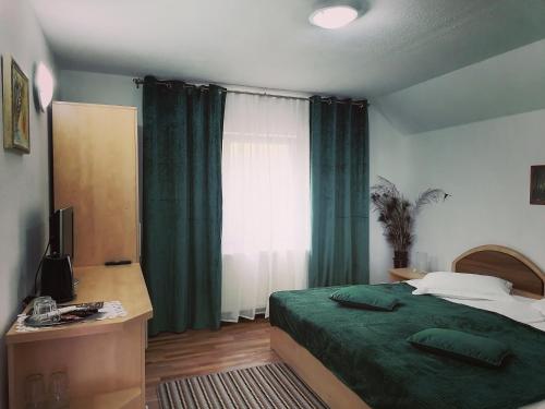 um quarto com uma cama verde e uma janela em Motorom em Zarnesti