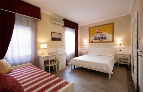 a bedroom with two beds and a desk and a window at Bed Bra in Verona