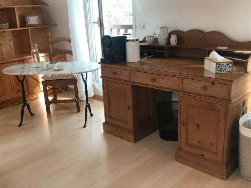 - une cuisine avec un bureau en bois et une table dans l'établissement Gîte Armalia, à Moëlan-sur-Mer