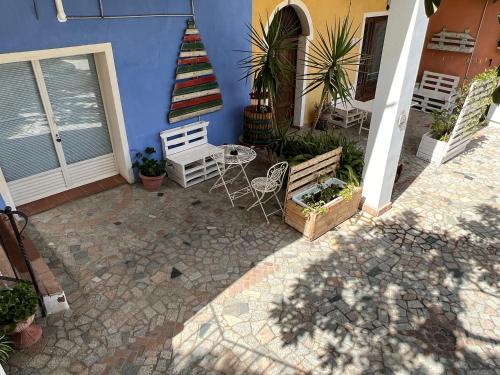 a patio with a table and chairs in front of a house at B&B Rita and Family in Loceri