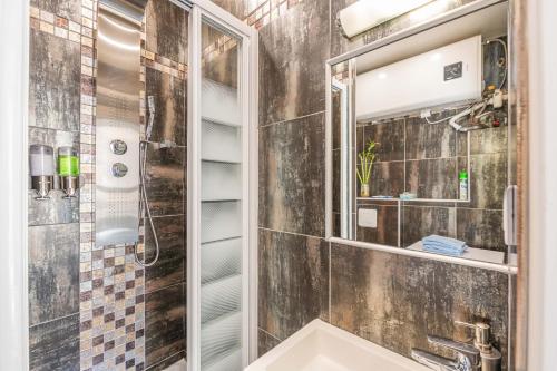 La salle de bains est pourvue d'un lavabo et d'un miroir. dans l'établissement Ma Douceur Paris La Défense, à Courbevoie