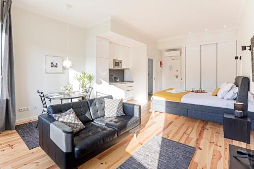 een woonkamer met een bed en een bank bij 150 Rivoli Apartments by LovelyStay in Porto