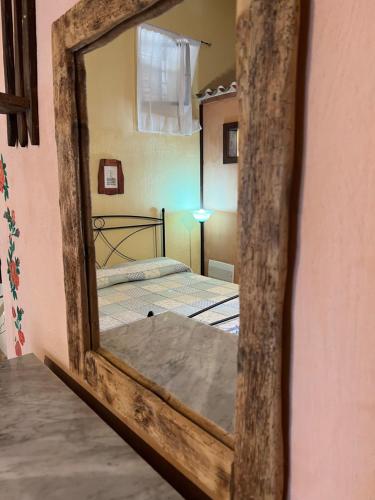 a mirror reflecting a bedroom with two beds in it at B&B Rita and Family in Loceri