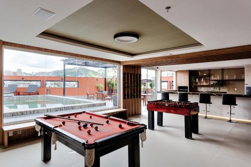 a room with a pool table and a swimming pool at Victory Business Hotel in Juiz de Fora