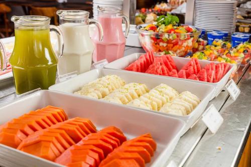 un buffet de différents types de nourriture dans les plateaux dans l'établissement Victory Business Hotel, à Juiz de Fora