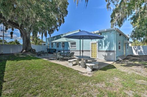 a blue house with a picnic table and an umbrella at Serene Daytona Beach House with Private Yard! in Daytona Beach