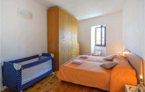 a bedroom with a bed with an orange blanket at Stunning Apartment In Stenico With Wifi in Stenico