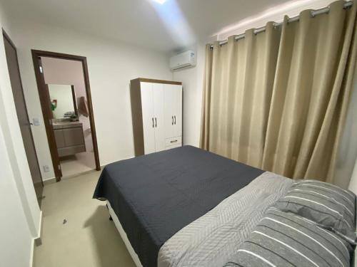 um pequeno quarto com uma cama e um espelho em Apartamento Prox. Unievangelica 201 em Anápolis