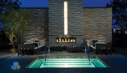a swimming pool in front of a brick building with a fireplace at StripViewSuites Two-Bedroom Con-Joined Exclusive Condo in Las Vegas