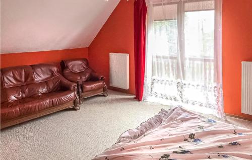 uma sala de estar com um sofá de couro e uma janela em 4 Bedroom Amazing Home In Serniki 