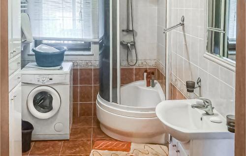 a bathroom with a washing machine and a sink at 4 Bedroom Amazing Home In Serniki 