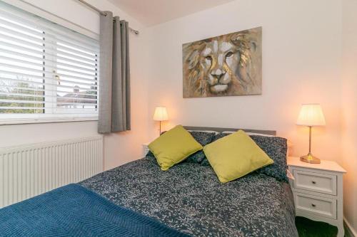 a bedroom with a bed with two yellow pillows at Archers Lodge in Stevenage