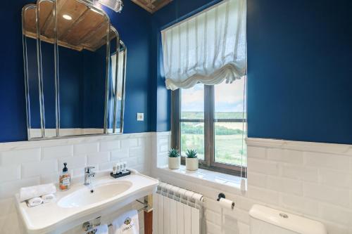 a blue bathroom with a sink and a window at Carpe Diem in Sladka Voda