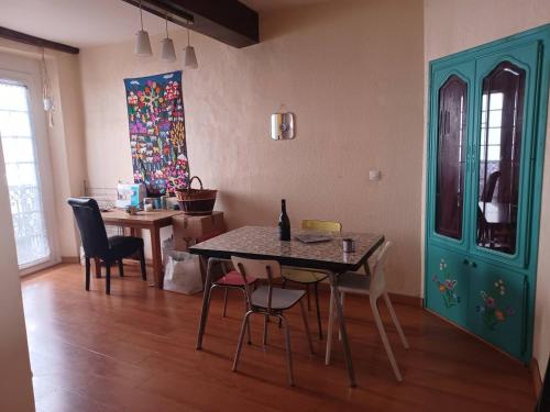 una sala da pranzo con tavolo, sedie e un dipinto di Appartement atypique centre ville Thuir a Thuir