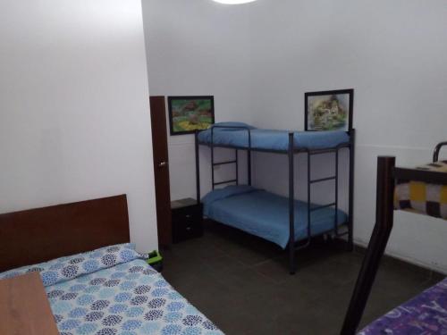 a bedroom with two bunk beds and a blue bed at HOTEL LA REPUBLICA MANIZALES in Manizales