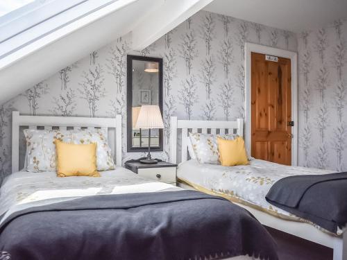 1 dormitorio con 2 camas, ventana y puerta en Saltburn Town House en Saltburn-by-the-Sea