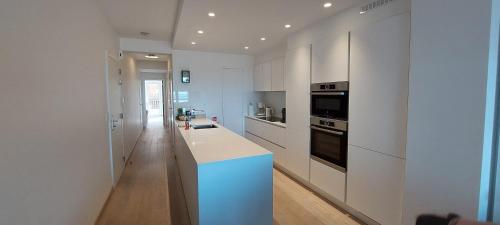 a kitchen with white cabinets and a blue counter top at Vakantie-appartement La Régence @ Oostende in Ostend