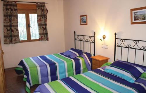 dwa łóżka ustawione obok siebie w sypialni w obiekcie Awesome Home In Montefrio w mieście Cortijo de los Gitanos